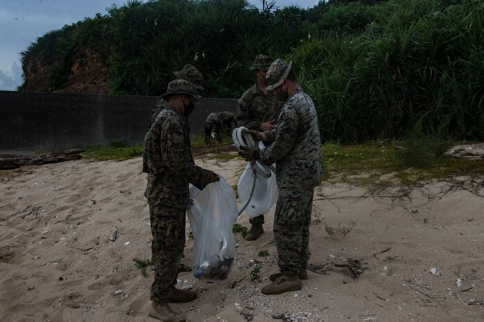 U.S. Marines clean the beach at Kin Blue, Okinawa, Japan, July 25.