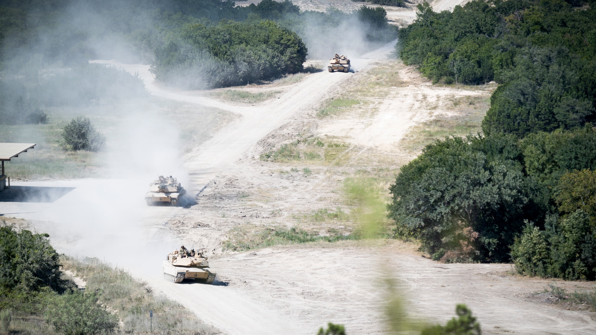 Three U.S. Army M1 Abrams tanks drive down a road during Exercise Pegasus Forge at Fort Hood, Texas, Aug. 11, 2020. The event took 45 days in the field leading up to the last full day filled with a fires coordination exercise. (U.S. Air Force photo by Senior Airman Lillian Miller)