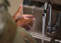 photo of hands next to running water
