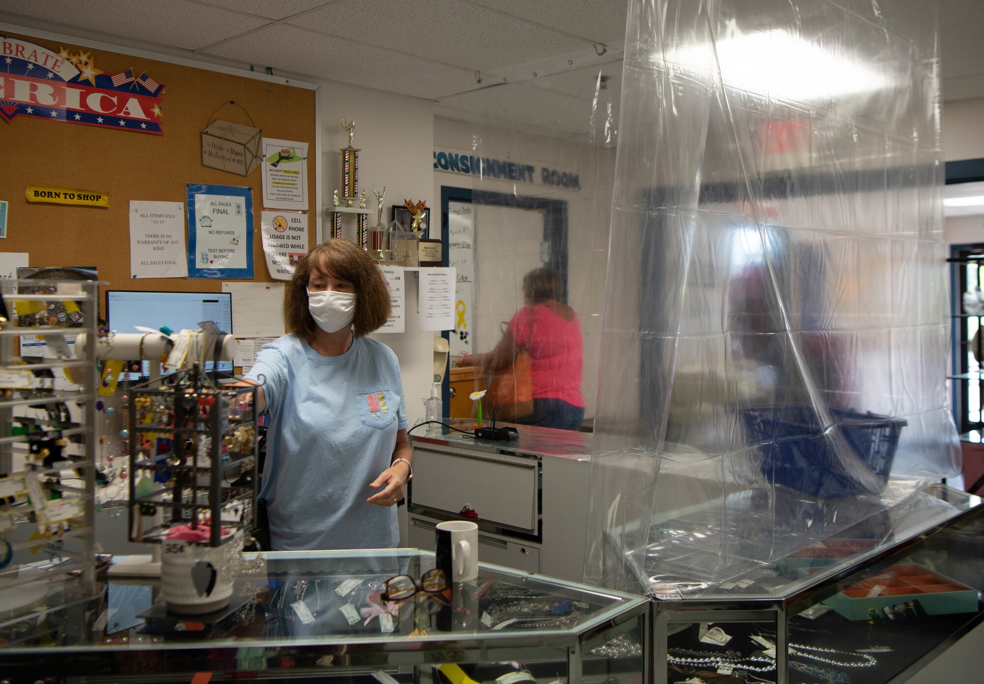 Woman rearranges product in a thrift shop.