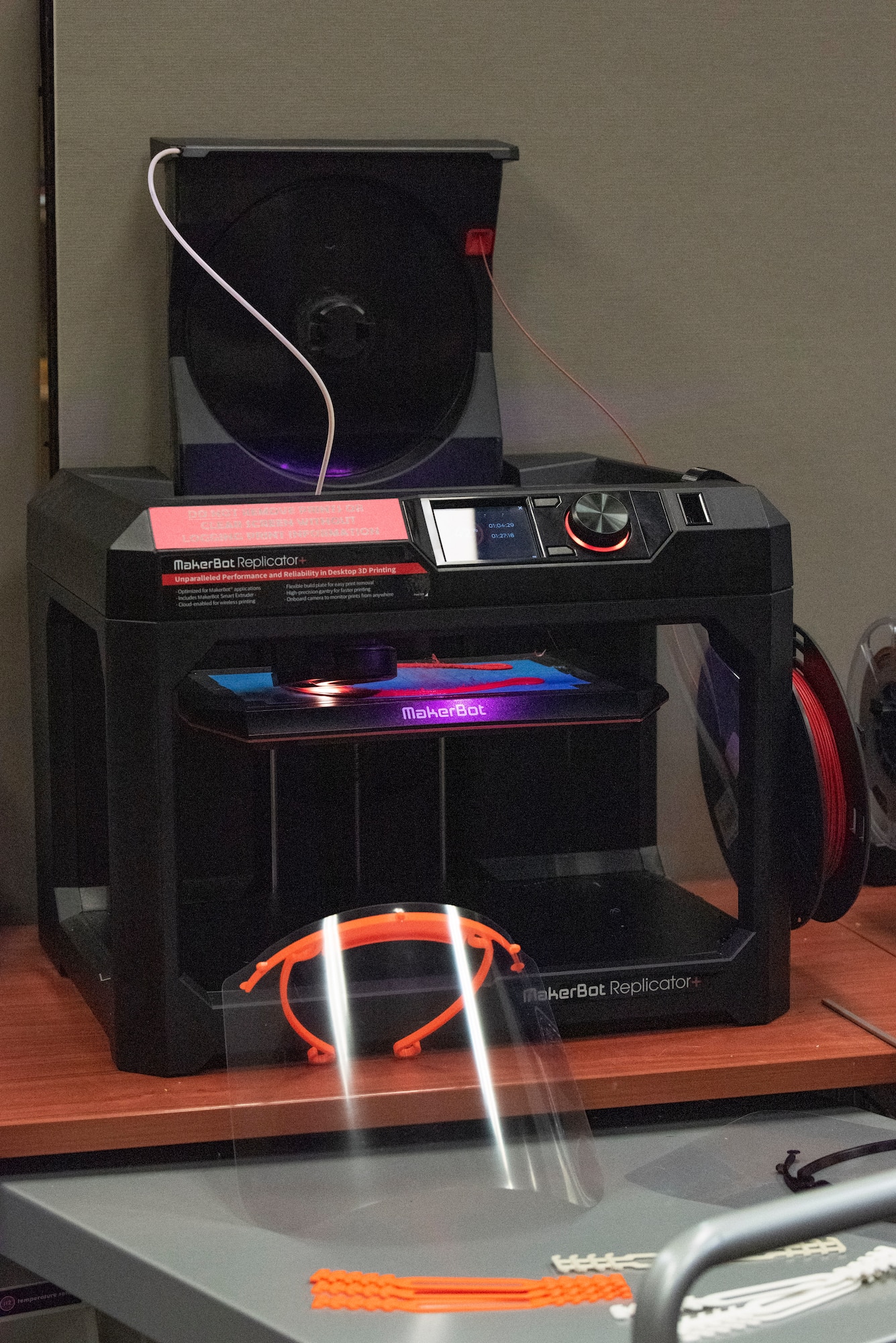 The 3-D printer at the base library prints a face shield for the 30th Medical Group July 31, 2020, at Vandenberg Air Force Base, Calif. Maj. Jonathan Wavell, Combined Force Space Components Command targets chief, began making personal protective equipment at the library during the beginning of the COVID-19 pandemic to provide for front line workers and those in need with mask extenders. (U.S. Air Force photo by Senior Airman Hanah Abercrombie)
