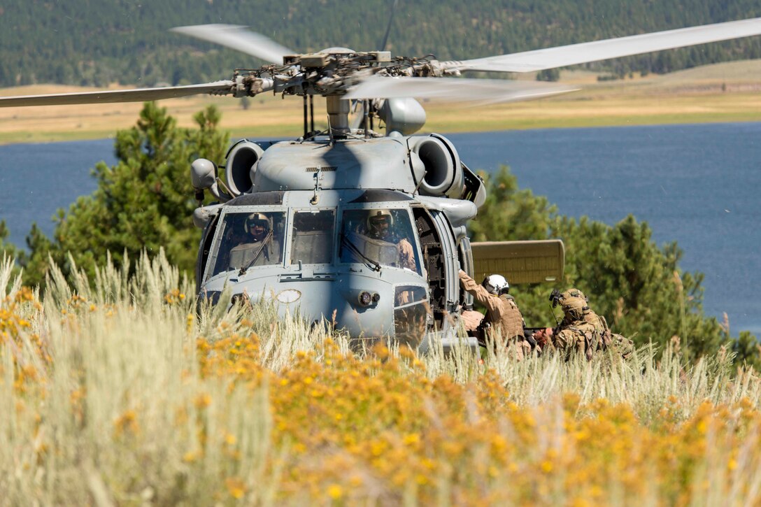 A group of airmen enter a helicopter.