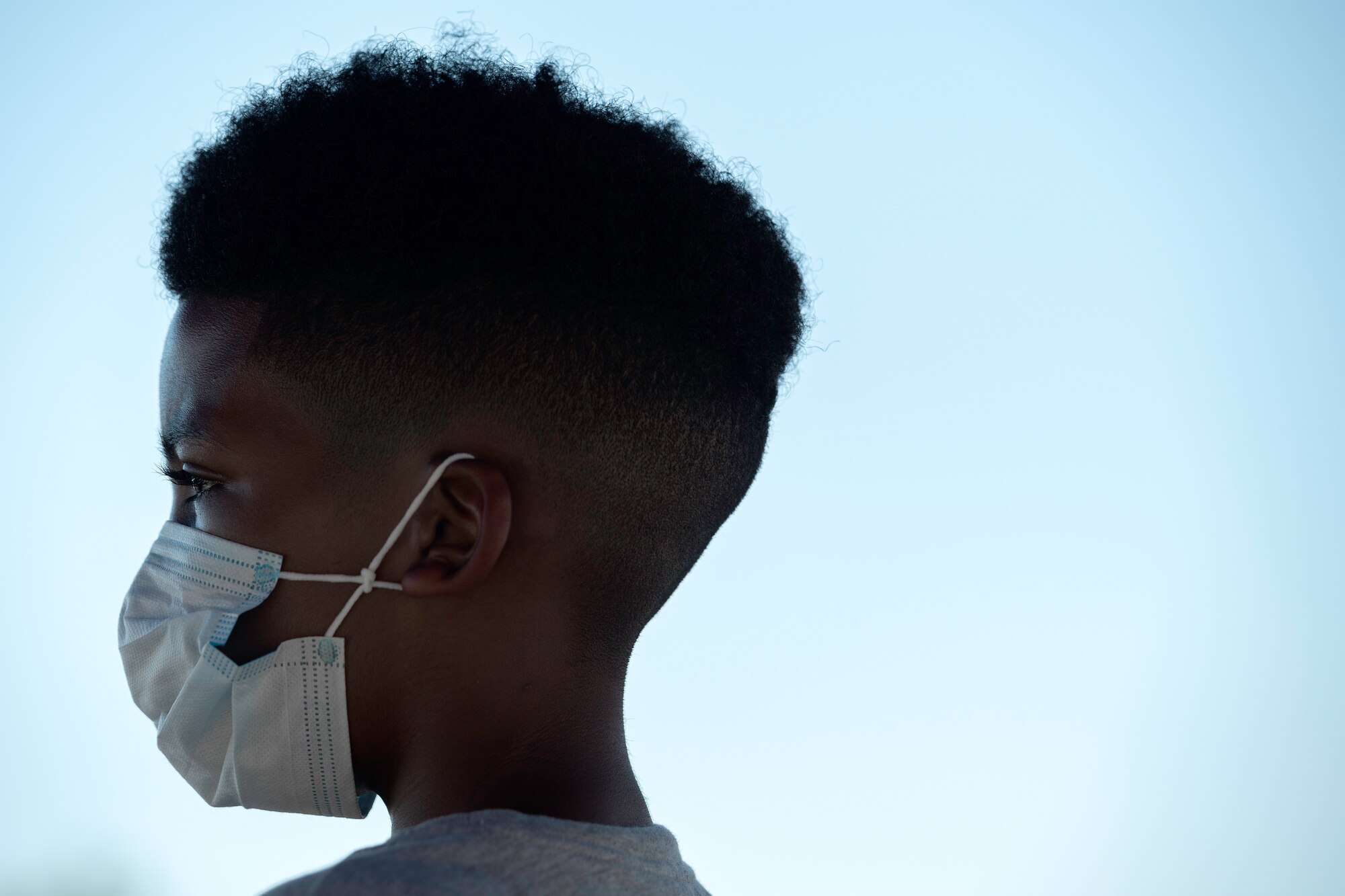 Camron Pressley, an elementary school student, watches as cars pull up to receive a drawstring backpack full of school supplies during the School Supply Drive-By at Peterson Air Force Base, Aug. 14, 2020.