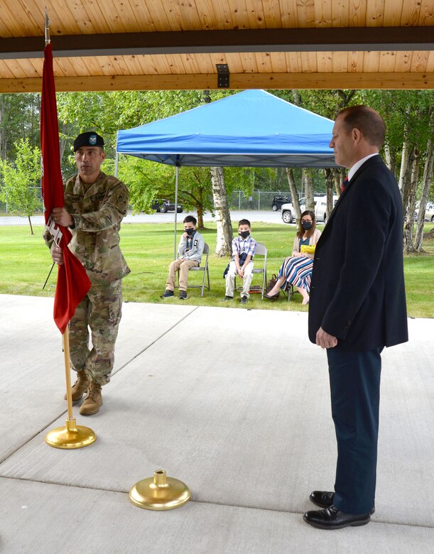 Col. Damon Delarosa, commander of the U.S. Army Corps of Engineers – Alaska District, prepares to place the guidon in the stand in front of Randy Bowker, chief of the Program and Project Management Division, signifying the start of his command of the Alaska District today during a ceremony at the headquarters building on Joint Base Elmendorf-Richardson.