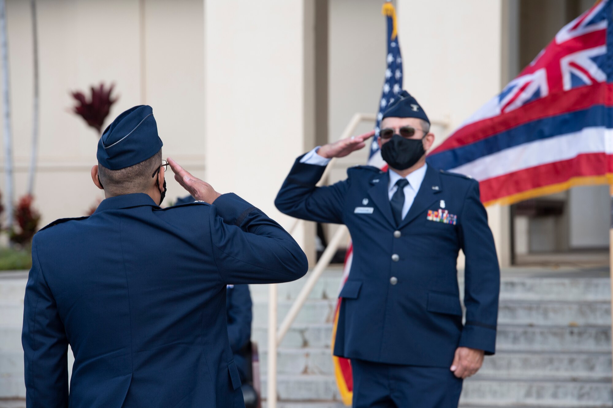 A photo of U.S. Air Force Col. Lee Bradshaw receiving one last salute as the 624th Aeromedical Staging Squadron commander from Lt. Col. Regan Ramos, 624th ASTS chief of nursing services, during the 624th ASTS change of command ceremony in front of the 15th Medical Group building at Joint Base Pearl Harbor-Hickam, Hawaii, Aug. 8, 2020.