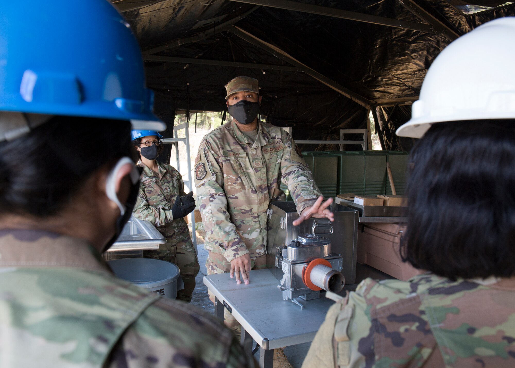 Airmen talk inside field kitchen after setting it up.