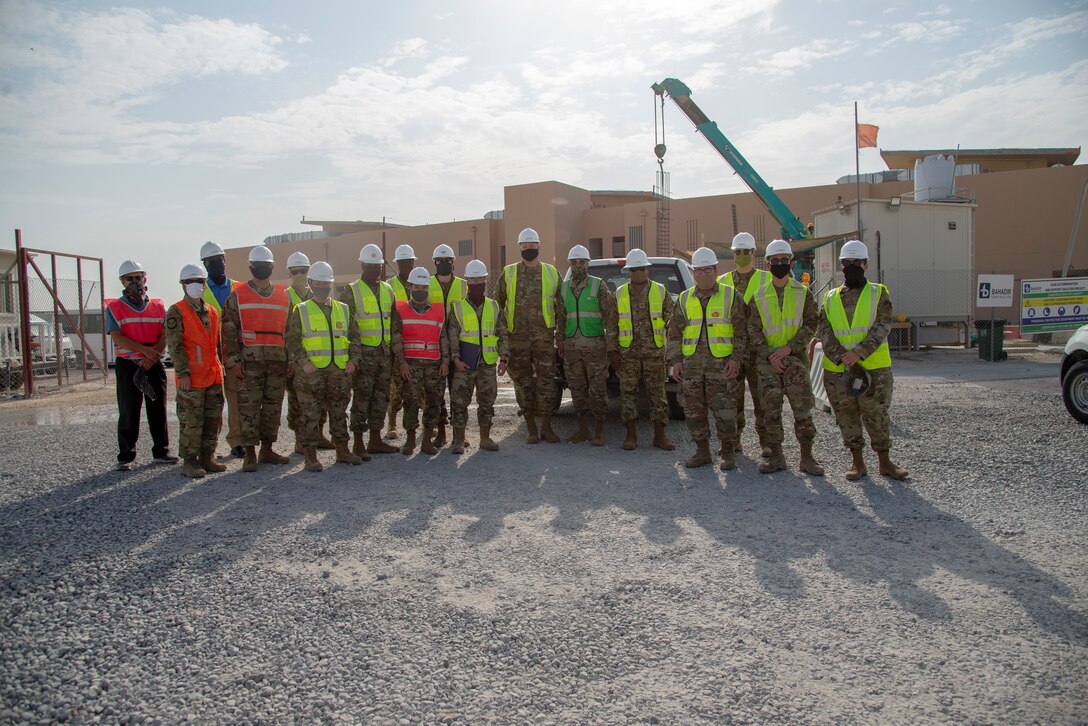 Members of the 379th Air Expeditionary Wing leadership and service members pose for a photo in front of new dorm construction at Al Udeid Air Base, Qatar, Aug. 10, 2020. The construction at Al Udeid is a Qatar-led, funded, and executed project to build 10 state-of-the-art dormitories, two dining facilities, and three mission support facilities slated for completion in the near future in an effort to increase quality of life for the service members at the installation. The 379th Expeditionary Mission Support Group leadership and those involved in this project brought Airmen to the dorm to get feedback on the layout and furniture to ensure it meets their needs. The transition from expeditionary to enduring, modern facilities will improve the standard of living, alleviate stress, and provide safer hardened facilities for service members at Al Udeid Air Base.