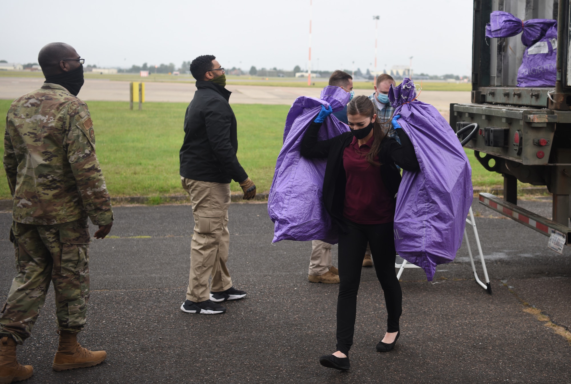 Team Mildenhall members and Air Force Office of Special Investigations agents off-load packages during an AFOSI-led good order and discipline search at RAF Mildenhall, England, July 27, 2020. The AFOSI investigates serious offenses including espionage, terrorism, drug use and other illegal activities that undermine the mission of the Department of Defense. (U.S. Air Force photo by Senior Airman Brandon Esau)