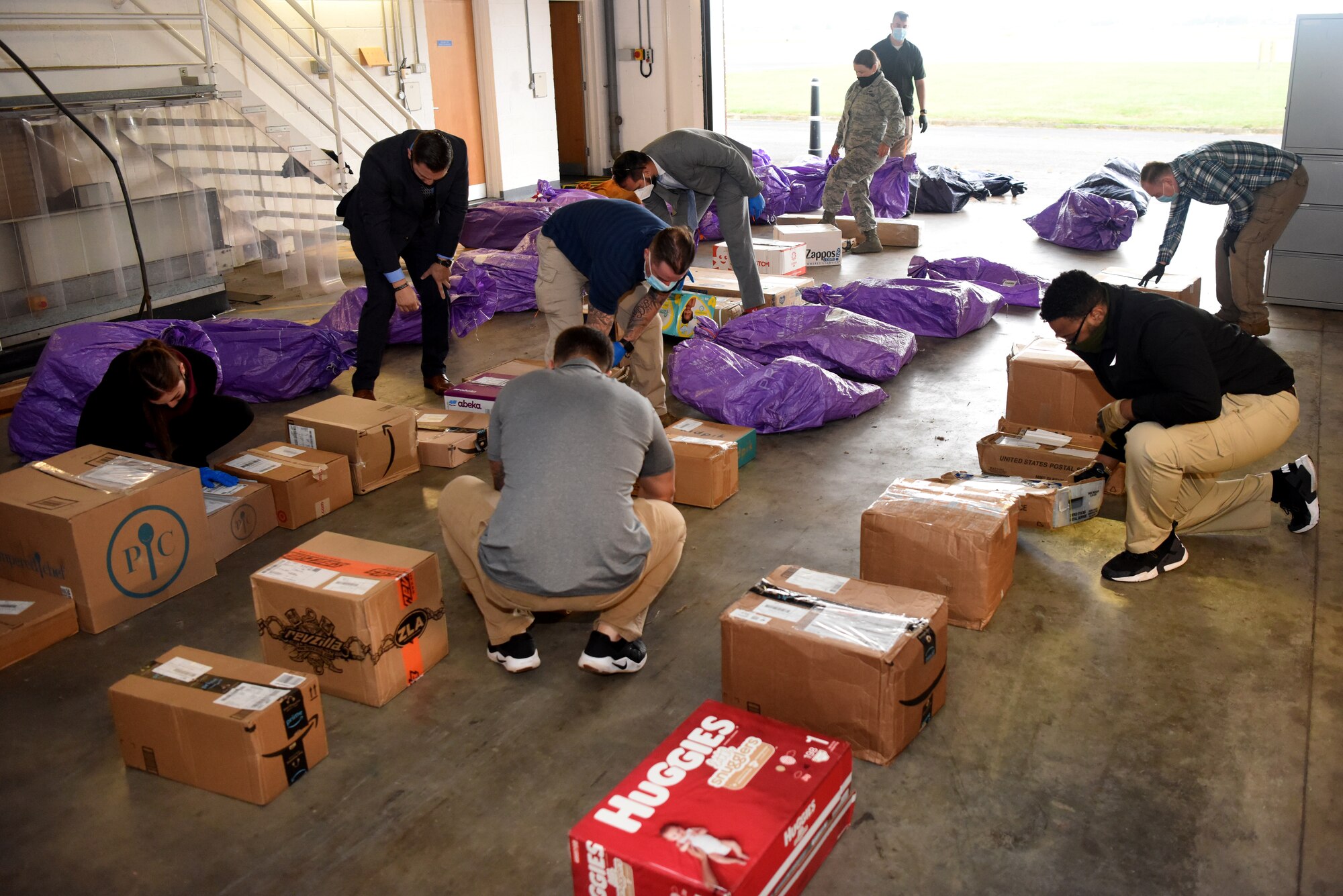 Team Mildenhall members and Air Force Office of Special Investigations agents search packages during an AFOSI-led good order and discipline search at RAF Mildenhall, England, July 27, 2020. AFOSI agents assigned to Detachment 512 work around-the-clock to identify, detect, deter and neutralize threats. (U.S. Air Force photo by Senior Airman Brandon Esau)