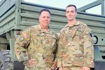 U.S. Army Chief Warrant Officer 5 David Corbi, left, and Sgt. David Corbi, both with 1st Battalion, 137th Aviation Regiment, 28th Expeditionary Combat Aviation Brigade, pose for a photo after a promotion ceremony in their honor at the 28th ECAB's mobilization station.
