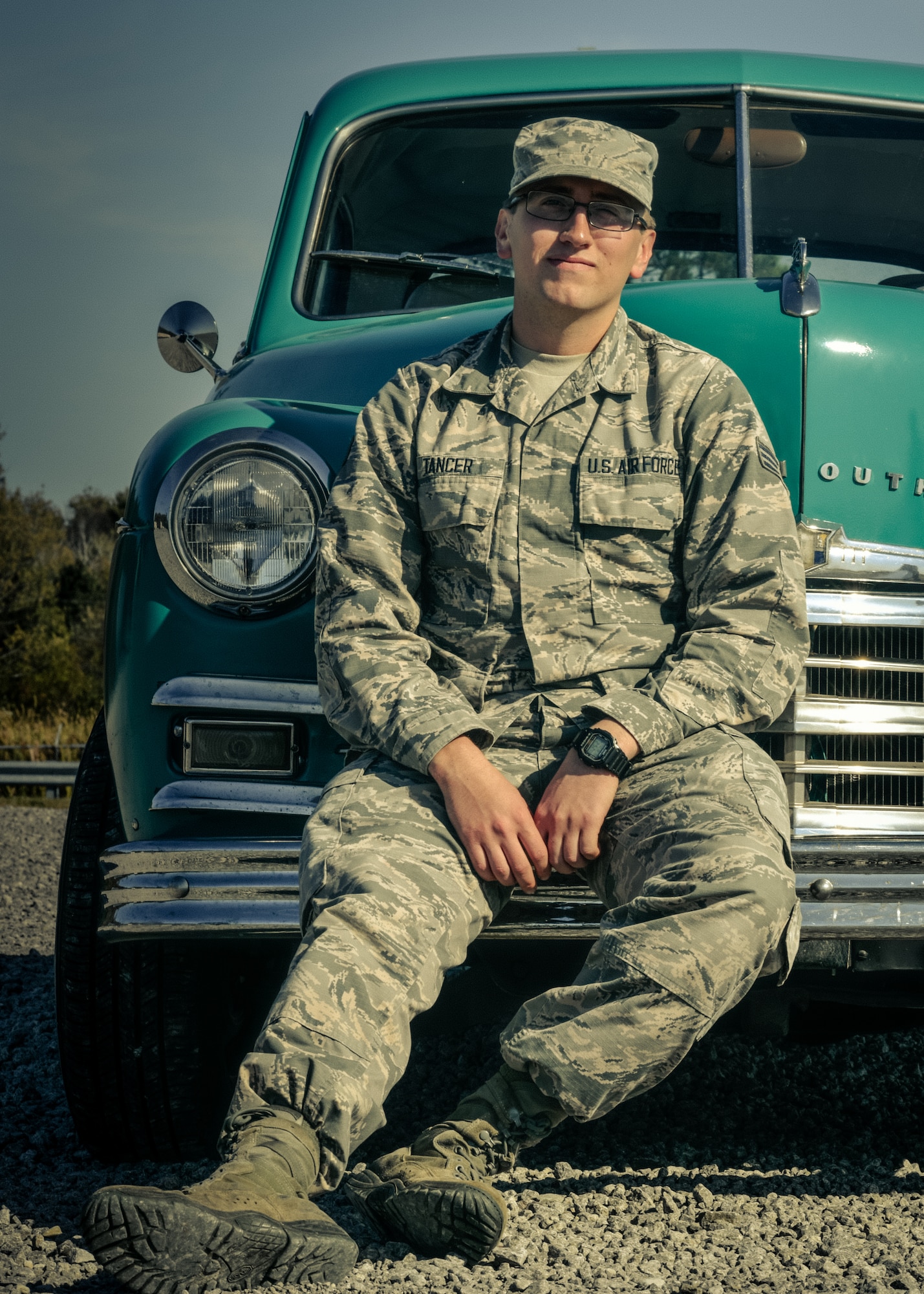 Senior Airman Noah Tancer, a public affairs specialist with the 910th Airlift Wing, sits on the front bumper of a 1949 Plymouth on October 15, 2019, at Youngstown Air Reserve Station. Tancer along with a handful of family members spent over three years restoring the car after Tancer purchased it for $1,000 upon graduating from high school.