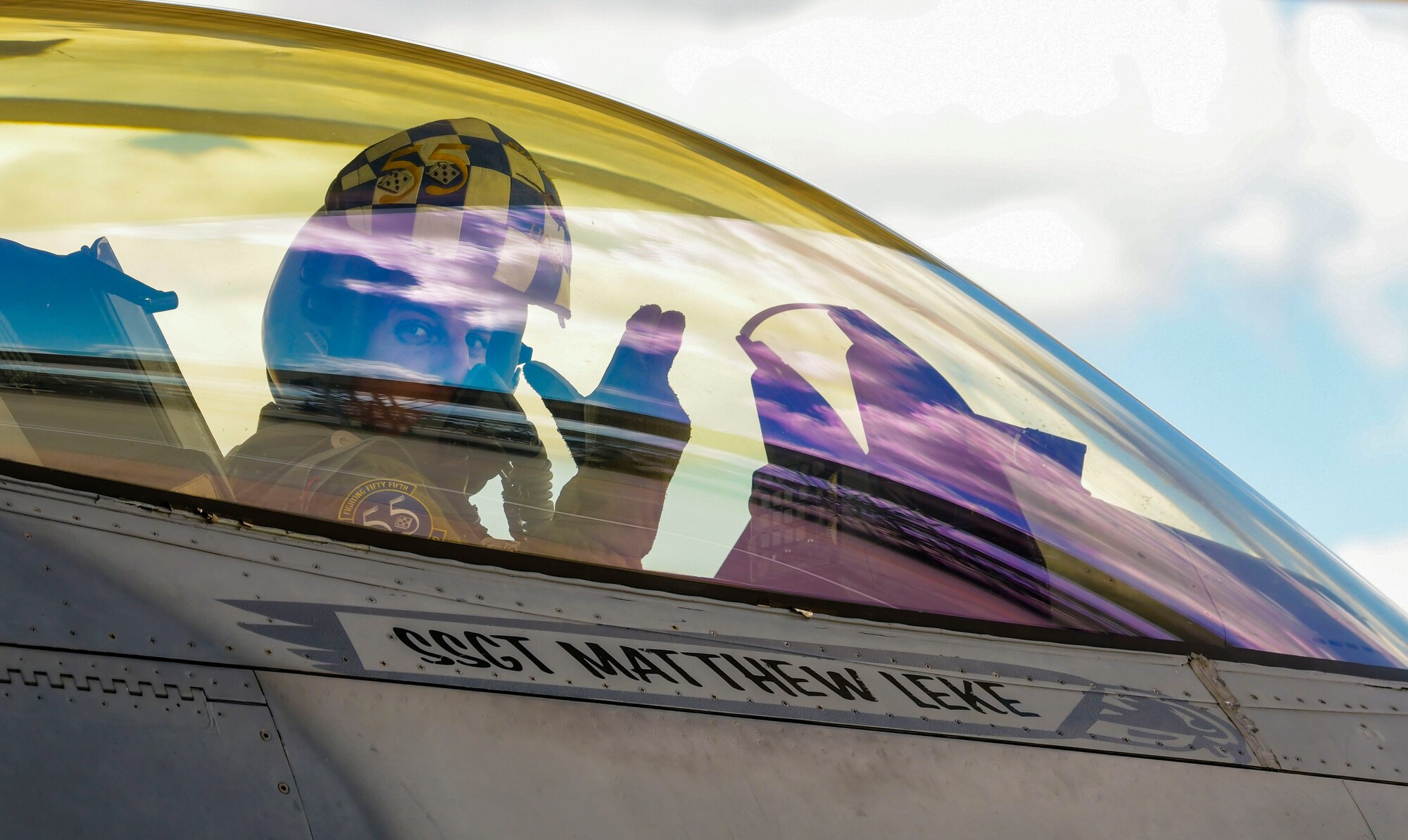 Fighter pilot sits in cockpit.