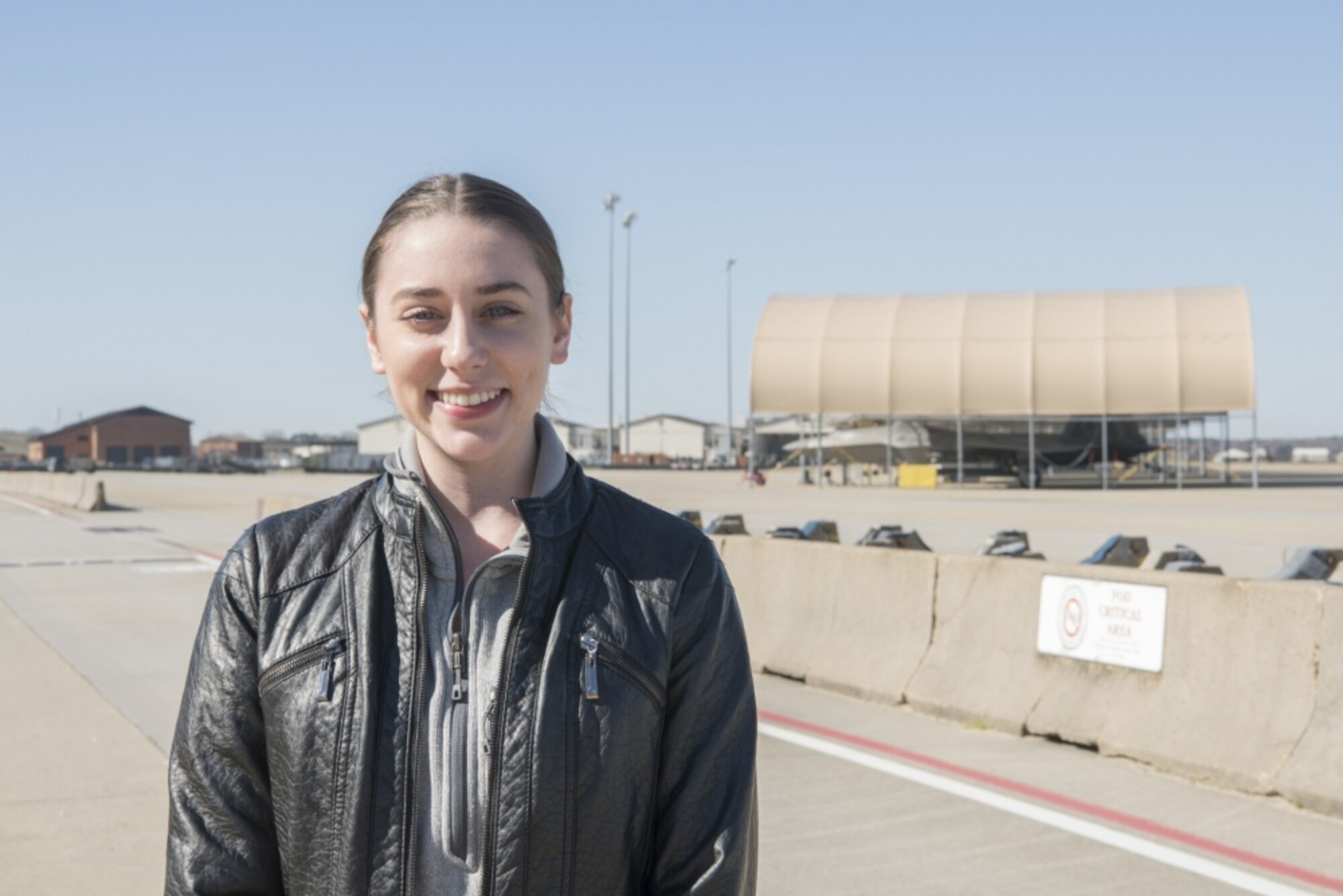 A woman smiling in front of the flight line