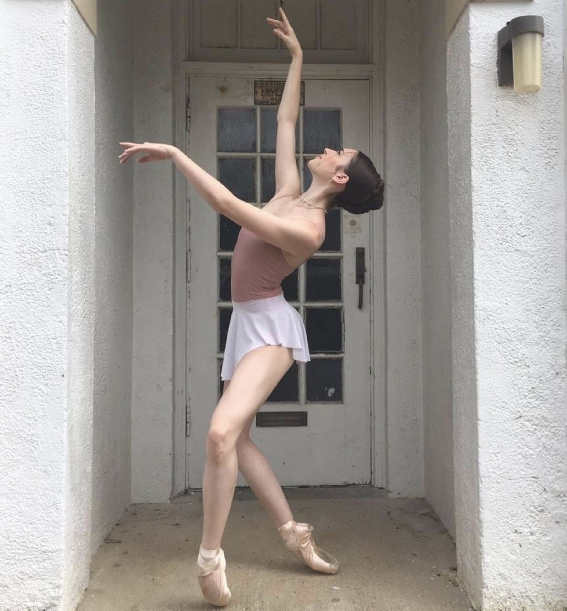 A ballerina poses in a doorway