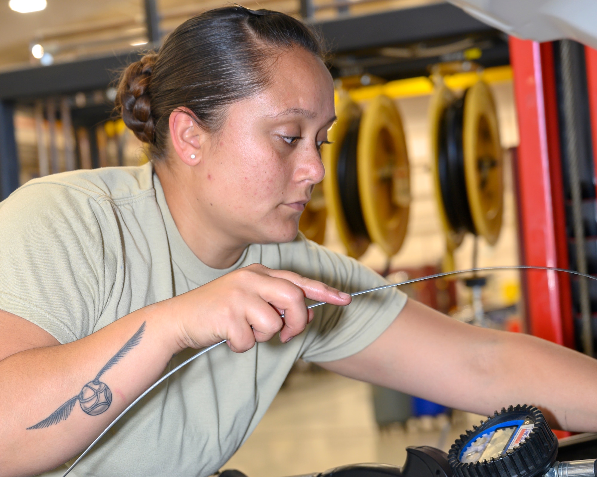 An Airman checks engine fluid levels inside an engine bay of a vehicle.