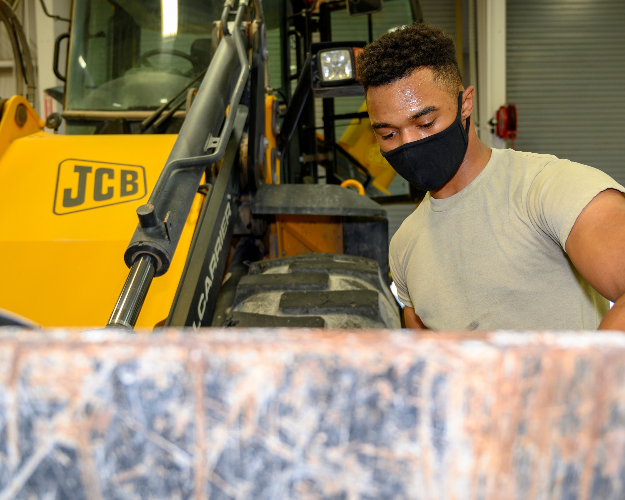 An Airman greases the joints of a special purpose heavy vehicle.