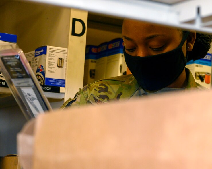 An Airman looks over vehicle parts while doing inventory.