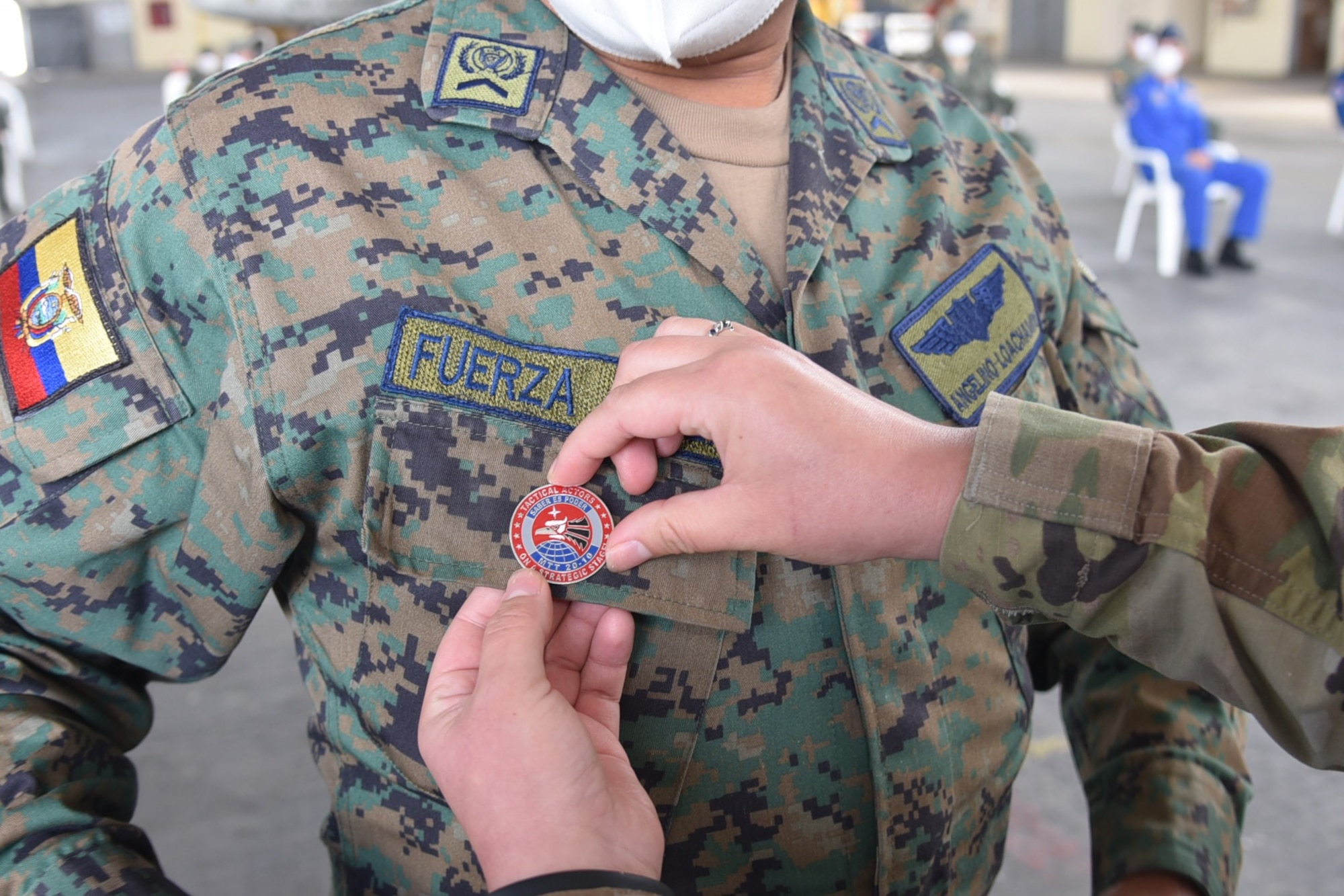 U.S. Air Force Capt. Kaitlin Morones, 571st Mobility Support Advisory Squadron logistics air advisor, places a pin on Sargento Primero Juan Germán Nieto Calderón from the Fuerza Aérea Ecuatoriana, during a graduation ceremony July 31, 2020, at Cotopaxi Air Force Base in Latacunga, Ecuador.  (U.S. Air Force photo by Master Sgt. Freddy Muñoz)