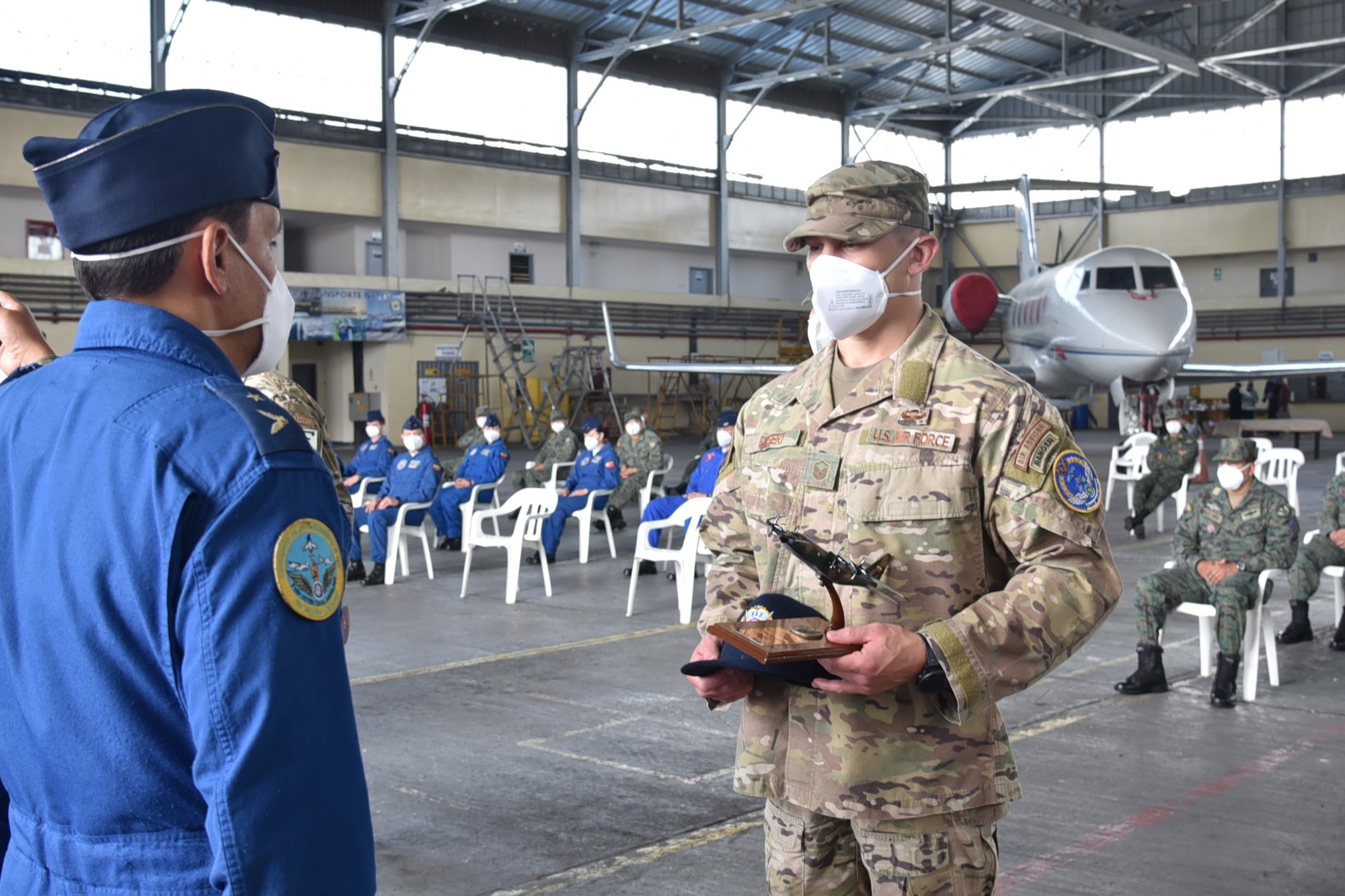 U.S. Air Force Master Sgt. Caleb Dysert, 571st Mobility Support Advisory Squadron team sergeant, receives a model L-100 aircraft and a Fuerza Aérea Ecuatoriana, ball cap as a gift of appreciation from FAE Mayor Franklin Acosta July 31, 2020, at Cotopaxi Air Force Base in Latacunga, Ecuador. (U.S. Air Force photo by Master Sgt. Freddy Muñoz)