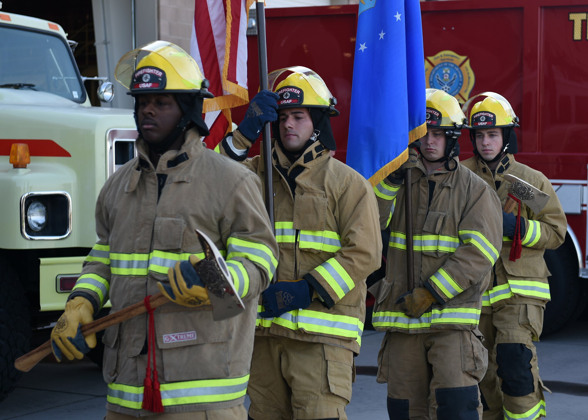 photo of four Air Force firefighters presenting the U.S. and Air Force flag before the singing of the national anthem