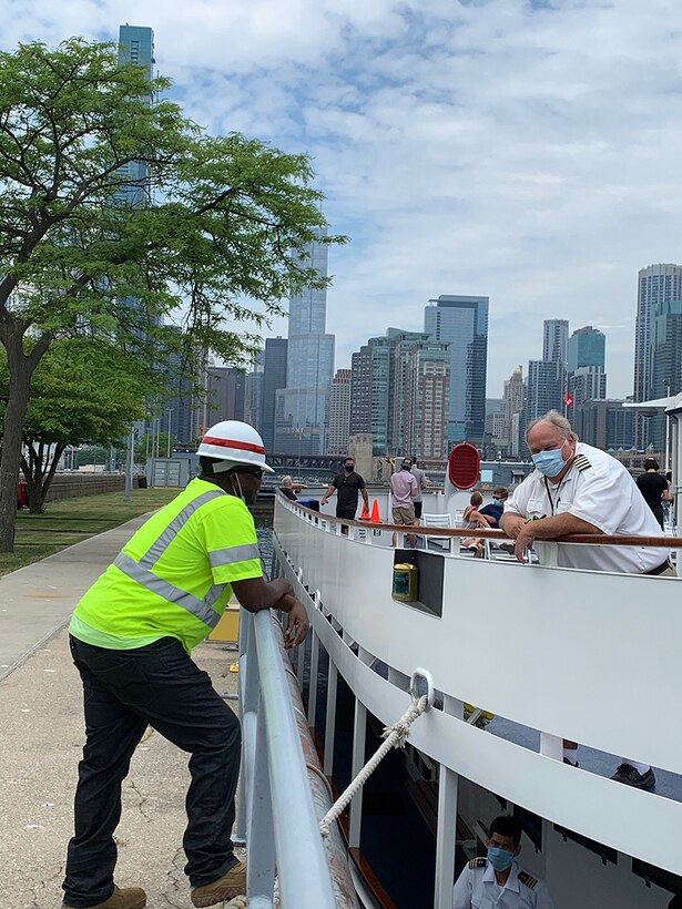 Paul Belate, summer hire, at the Chicago Harbor Lock talking to a co-captain of a tour boat.