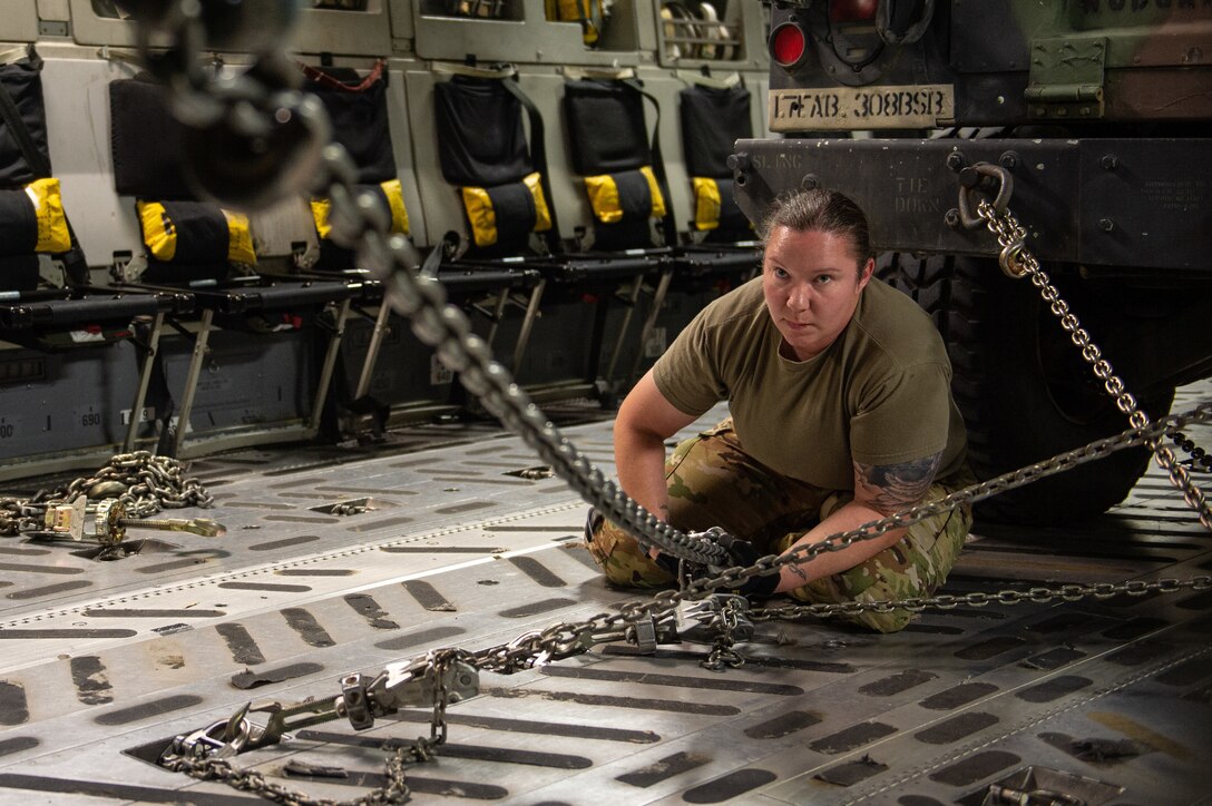 Tech. Sgt. Jenna Williams, 8th Airlift Squadron loadmaster, secures a vehicle inside a C-17 Globemaster III