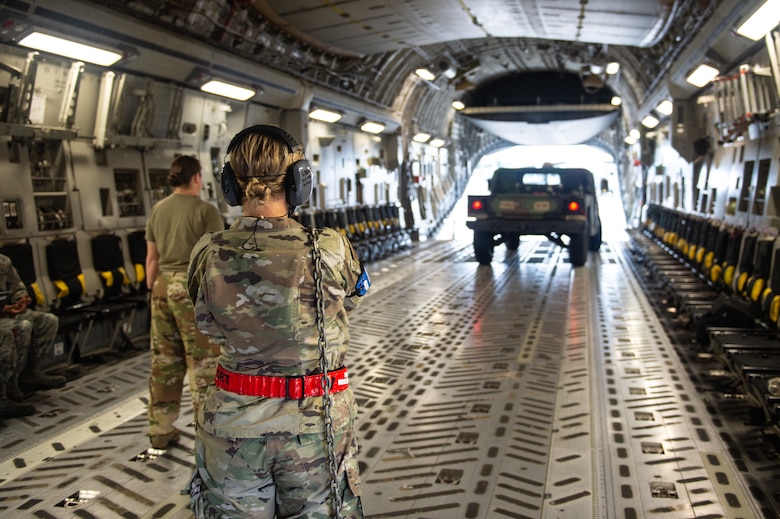Senior Airman Grace Brabender, 62nd Aerial Port Squadron, prepares to secure a vehicle inside a C-17 Globemaster III