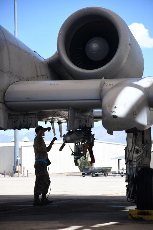a photo of an airman inspecting an a-10