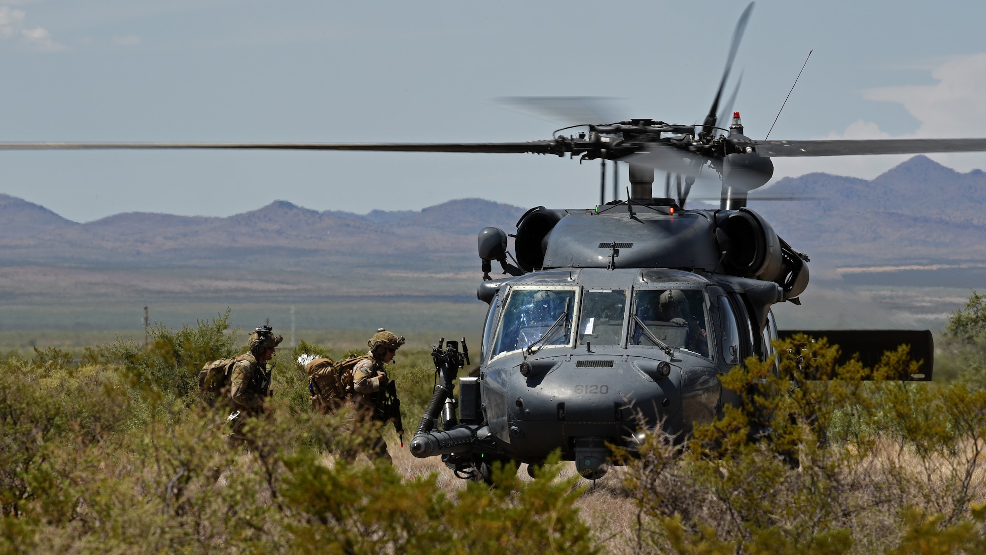 photo of an Air Force rescue team taking a simulated downed pilot into an HH-60G Pavehawk helicopter for rescue