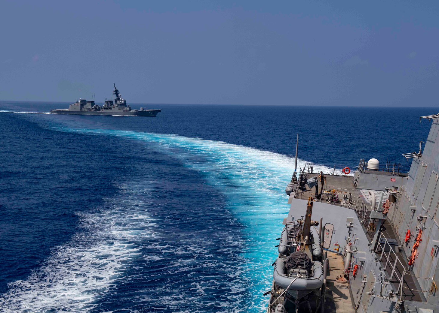 The Arleigh Burke-class guided-missile destroyer USS Mustin (DDG 89) sails alongside the Japanese Maritime Self-Defense Force ship JS Suzutsuki (DD 117). Mustin is underway conducting operations in support of security and stability in the Indo-Pacific while assigned to Destroyer Squadron (DESRON) 15, the Navy’s largest forward-deployed DESRON and the U.S. 7th Fleet’s principal surface force.