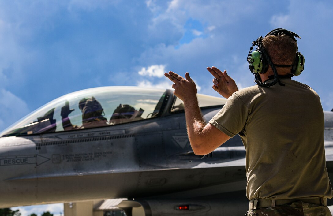 Picture of two Airmen and F-16