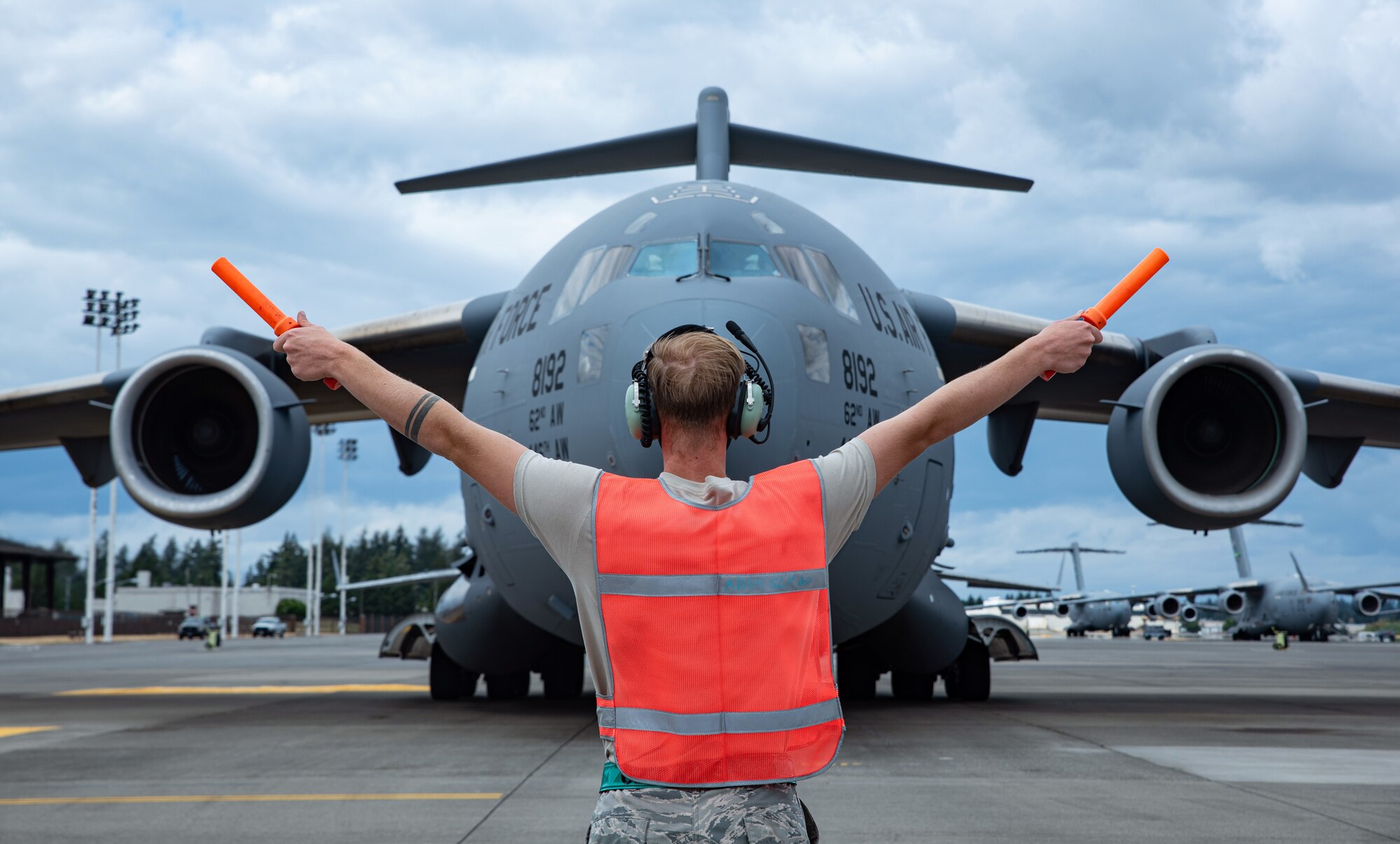 Airman 1st Class David Newgent, 62nd Aircraft Maintenance Squadron crew chief, marshals a C-17 Globemaster III to its parking spot during Exercise Long Hammer/Rainier War at Joint Base Lewis-McChord, Wash., Aug. 10, 2020. Exercises like this maintain Team McChord’s readiness to deploy and operate anywhere anytime. (U.S. Air Force photo by Senior Airman Tryphena Mayhugh)
