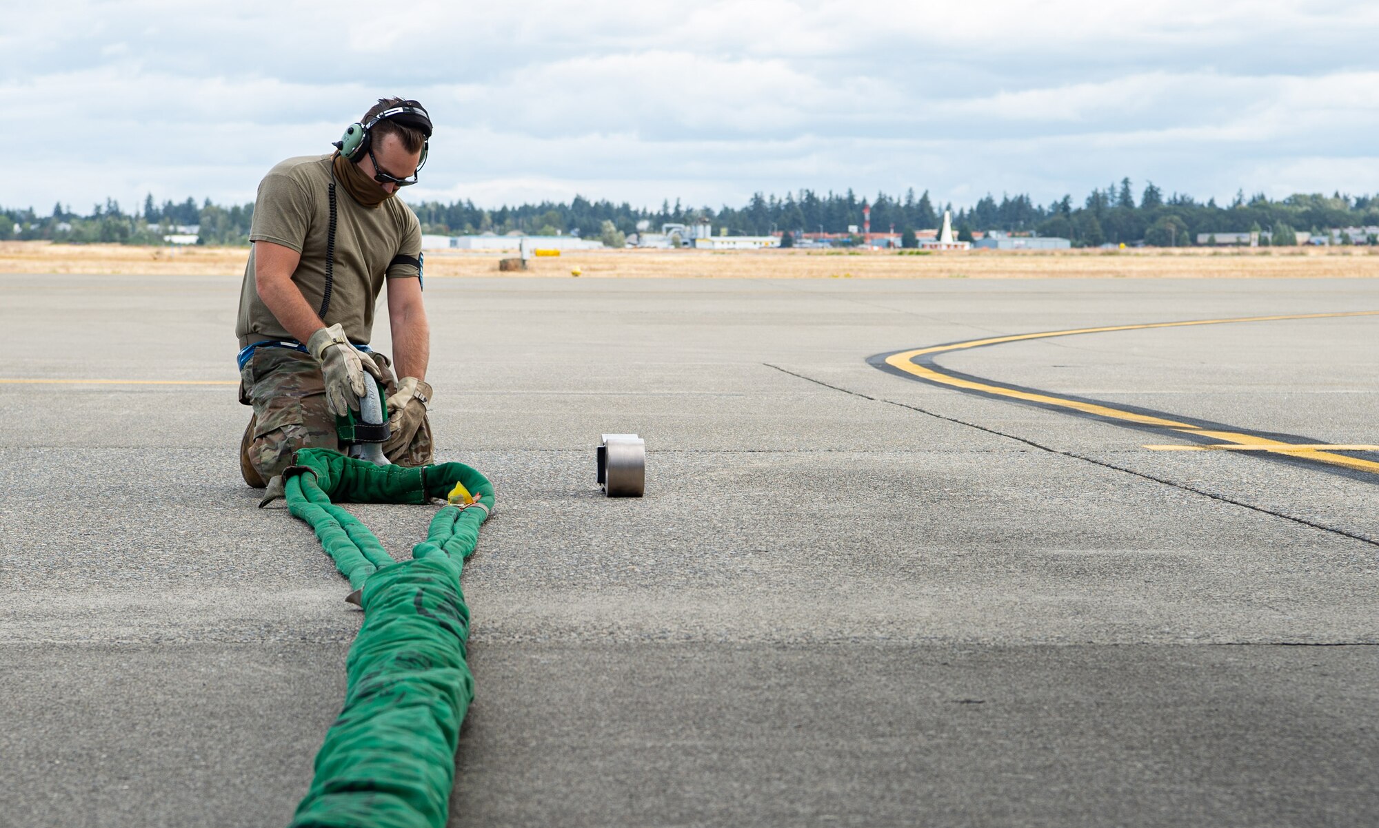 An Airman assigned to the 62nd Maintenance Squadron Crash Damaged or Disabled Aircraft Recovery (CDDAR) team sets up the attachment for the towing cable for a simulated damaged C-17 Globemaster III during Exercise Long Hammer/Rainier War at Joint Base Lewis-McChord, Wash., Aug. 10, 2020. The week-long exercise evaluated Team McChord’s ability to conduct airlift operations while complying with real-world COVID-19 pandemic countermeasures. (U.S. Air Force photo by Senior Airman Tryphena Mayhugh)