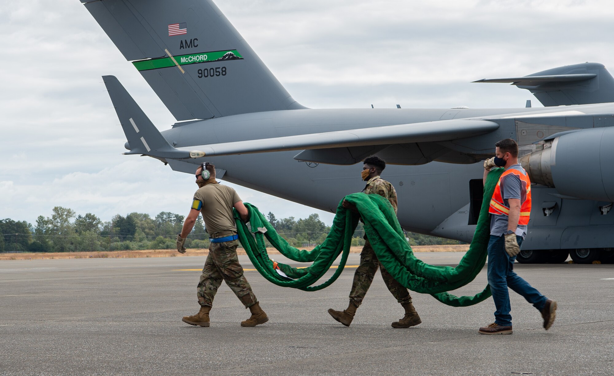 Airmen assigned to the 62nd Maintenance Squadron Crash Damaged or Disabled Aircraft Recovery (CDDAR) team carry a towing cable for a simulated damaged C-17 Globemaster III during Exercise Long Hammer/Rainier War at Joint Base Lewis-McChord, Wash., Aug. 10, 2020. The week-long exercise evaluated Team McChord’s ability to rapidly deploy and conduct airlift operations in contested airspace. (U.S. Air Force photo by Senior Airman Tryphena Mayhugh) (Portions of this photo have been blurred for operational security)
