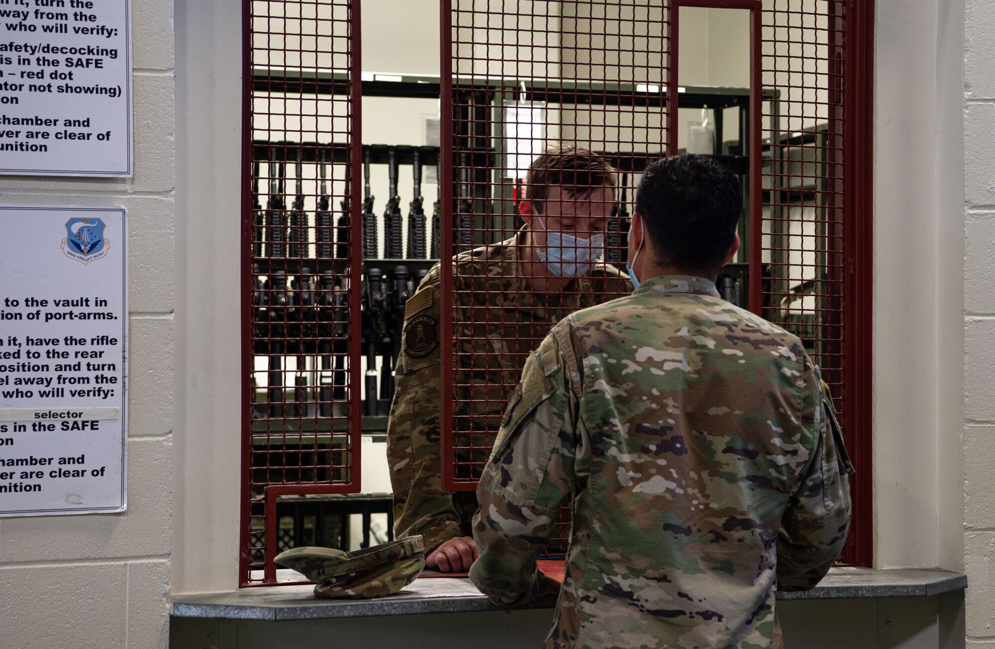 Staff Sgt. Tyler Stover, 627th Security Forces Squadron weapons vault NCO in charge, checks a simulated deploying Airman’s paperwork before issuing a weapon during Exercise Long Hammer/Rainier War at Joint Base Lewis-McChord, Wash., Aug. 10, 2020. The week-long exercise was designed to evaluate Team McChord’s ability to conduct airlift operations while complying with real-world COVID-19 pandemic countermeasures. (U.S. Air Force photo by Senior Airman Tryphena Mayhugh)