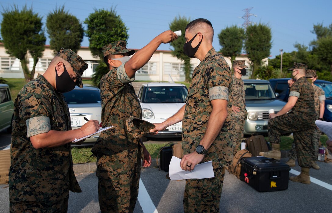 U.S. Marines with 3d Marine Expeditionary Brigade get their temperature checked before a flyaway drill at Camp Courtney, Okinawa, Japan, Aug. 18, 2020. The MEB continues to conduct essential, realistic training while adhering to strict COVID-19 safety protocols to mitigate the spread of COVID-19 and are prepared to deploy in support of our allies and partners throughout the region. 3d MEB is structured to rapidly respond to crisis around the globe immediately, effectively, and efficiently, whether they are humanitarian or combat-related.  (U.S. Marine Corps photo by Lance Cpl. Hannah Hall)