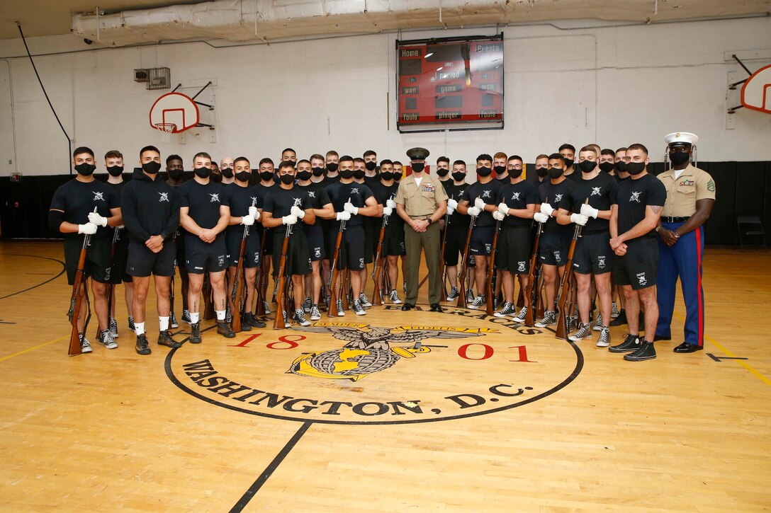 The 19th Sergeant Major of the Marine Corps, Sgt. Maj. Troy E. Black, poses for a photo with the Silent Drill Platoon after a practice session in preparation for the upcoming Friday Evening Parade at Marine Barracks Washington, D.C., Aug. 5, 2020. The tour offered a behind-the-scenes look at how the Marines prepare for their official presentations. The Marine Corps Silent Drill Platoon is a 24-man rile platoon that performs a unique precision drill exhibition that exemplifies the professionalism associated with the United States Marine Corps. (U.S. Marine Corps photo by Sgt. Victoria Ross)
