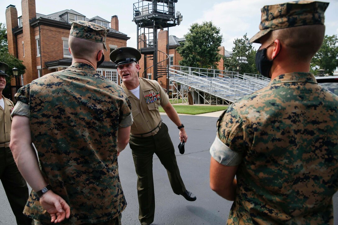 The 19th Sergeant Major of the Marine Corps, Sgt. Maj. Troy E. Black, hands a coin to Cpl. Tyler Easterling, a bugler from The Commandant’s Own Drum and Bugle Corps at Marine Barracks Washington, D.C., Aug. 5, 2020. The Marine was presented a coin for outstanding performance and discipline. The Drum and Bugle Corps provides music for the Commandant and Barracks commander. (U.S. Marine Corps photo by Sgt. Victoria Ross)