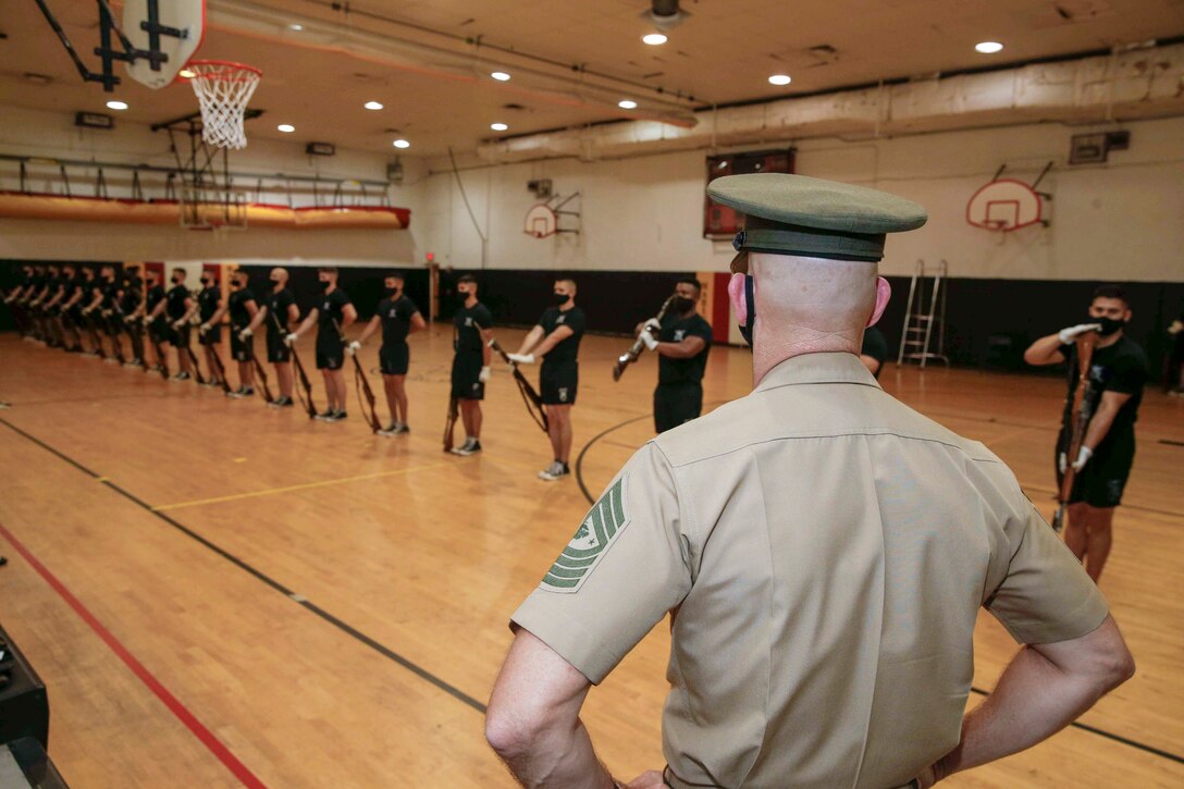 The 19th Sergeant Major of the Marine Corps, Sgt. Maj. Troy E. Black, observes the Silent Drill Platoon execute a practice session in preparation for the upcoming Friday Evening Parade at Marine Barracks Washington, D.C., Aug. 5, 2020. The tour offered a behind-the-scenes look at how the Marines prepare for their official presentations. The Marine Corps Silent Drill Platoon is a 24-man rile platoon that performs a unique precision drill exhibition that exemplifies the professionalism associated with the United States Marine Corps. (U.S. Marine Corps photo by Sgt. Victoria Ross)