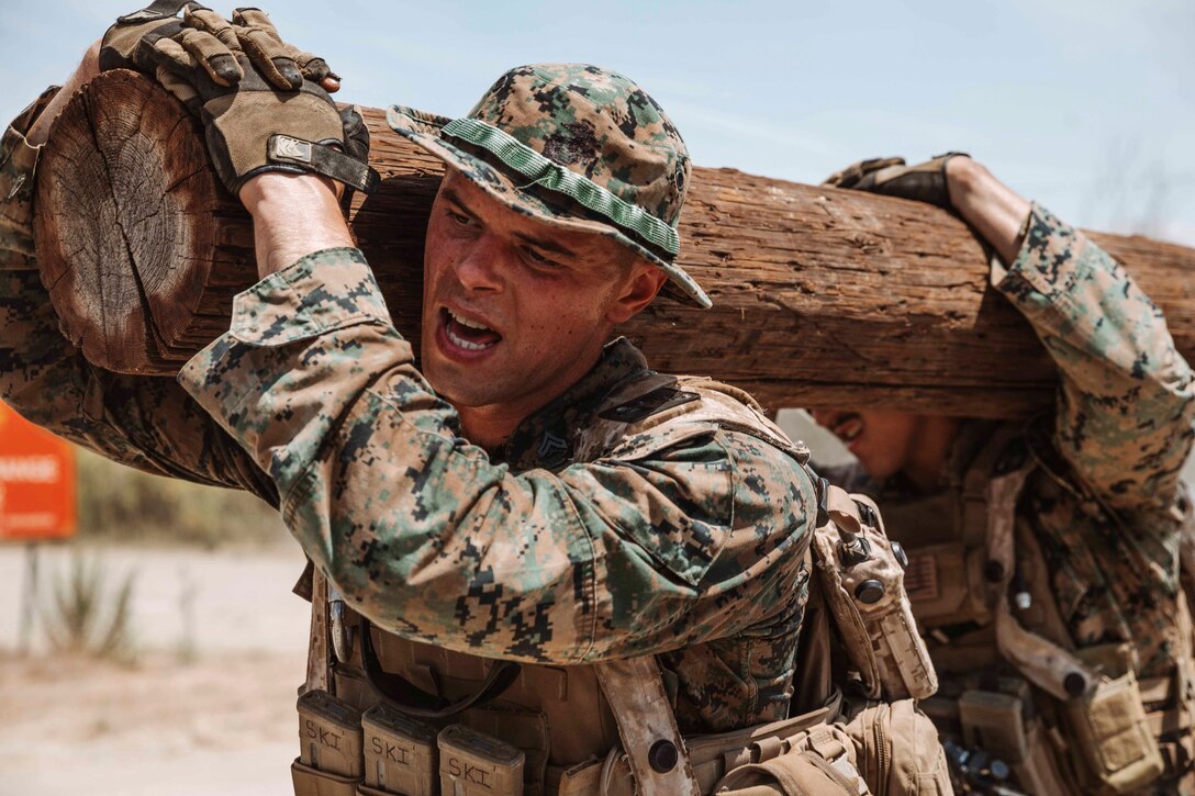 Marines carry a log.