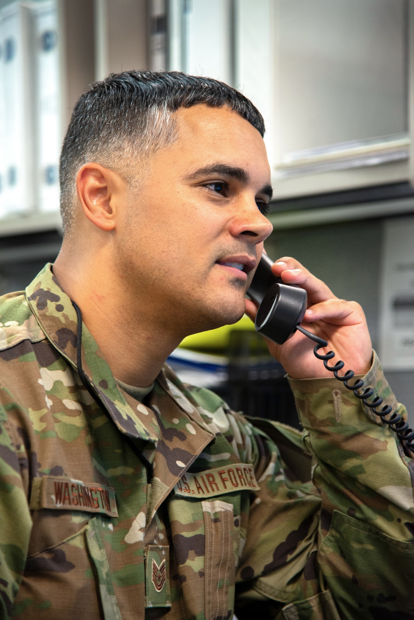 A photo of Tech. Sgt. Timothy A. Washington speaking with a coworker on the phone.