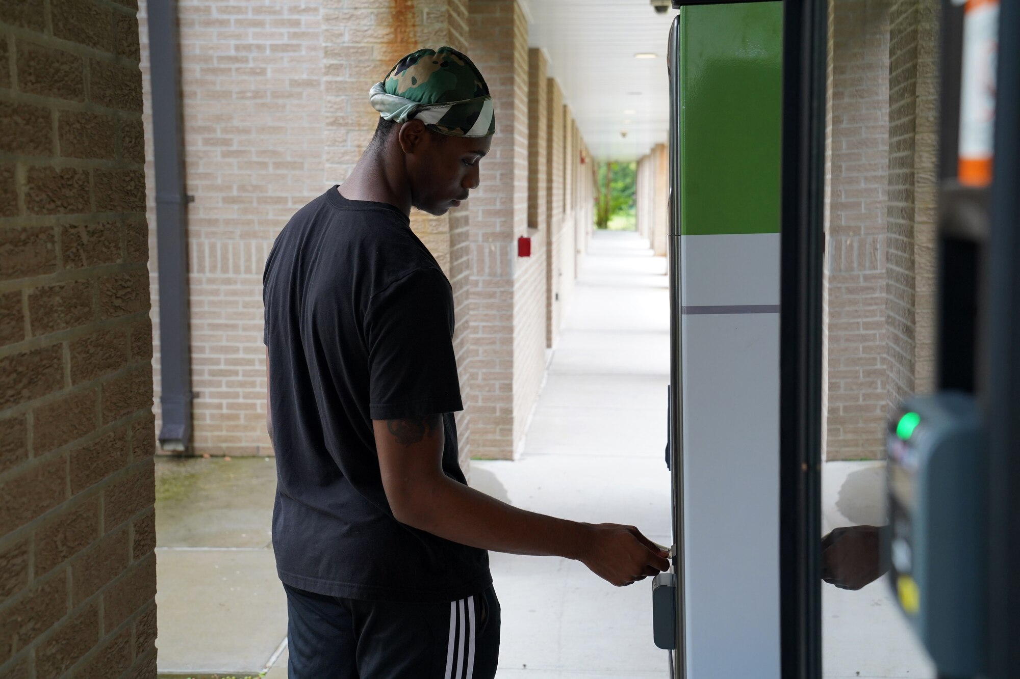 U.S. Air Force Airman 1st Class Chris Robinson, Aerospace Medicine Squadron medical technician, uses a vending machine at Biloxi Hall at Keesler Air Force Base, Mississippi, Aug. 13, 2020. Vending machines and dehumidifiers were provided to the permanent party dorms to improve the health and living standards of the Airmen. (U.S. Air Force photo by Airman 1st Class Seth Haddix)
