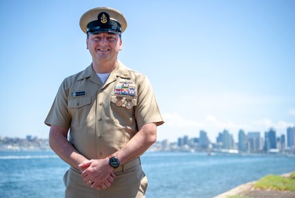Senior Chief Cryptologic Technician (Collection) Jamey Stewart, from Greenwood, S.C., assigned to Commander, Carrier Strike Group (CCSG) 15 poses for a photo in front of the San Diego skyline. CCSG-15 conducts integrated training to provide Fleet Commanders with deployable combat ready maritime forces in support of global operations. (U.S. Navy photo by Mass Communication Specialist 1st Class Christopher Cavagnaro/Released)