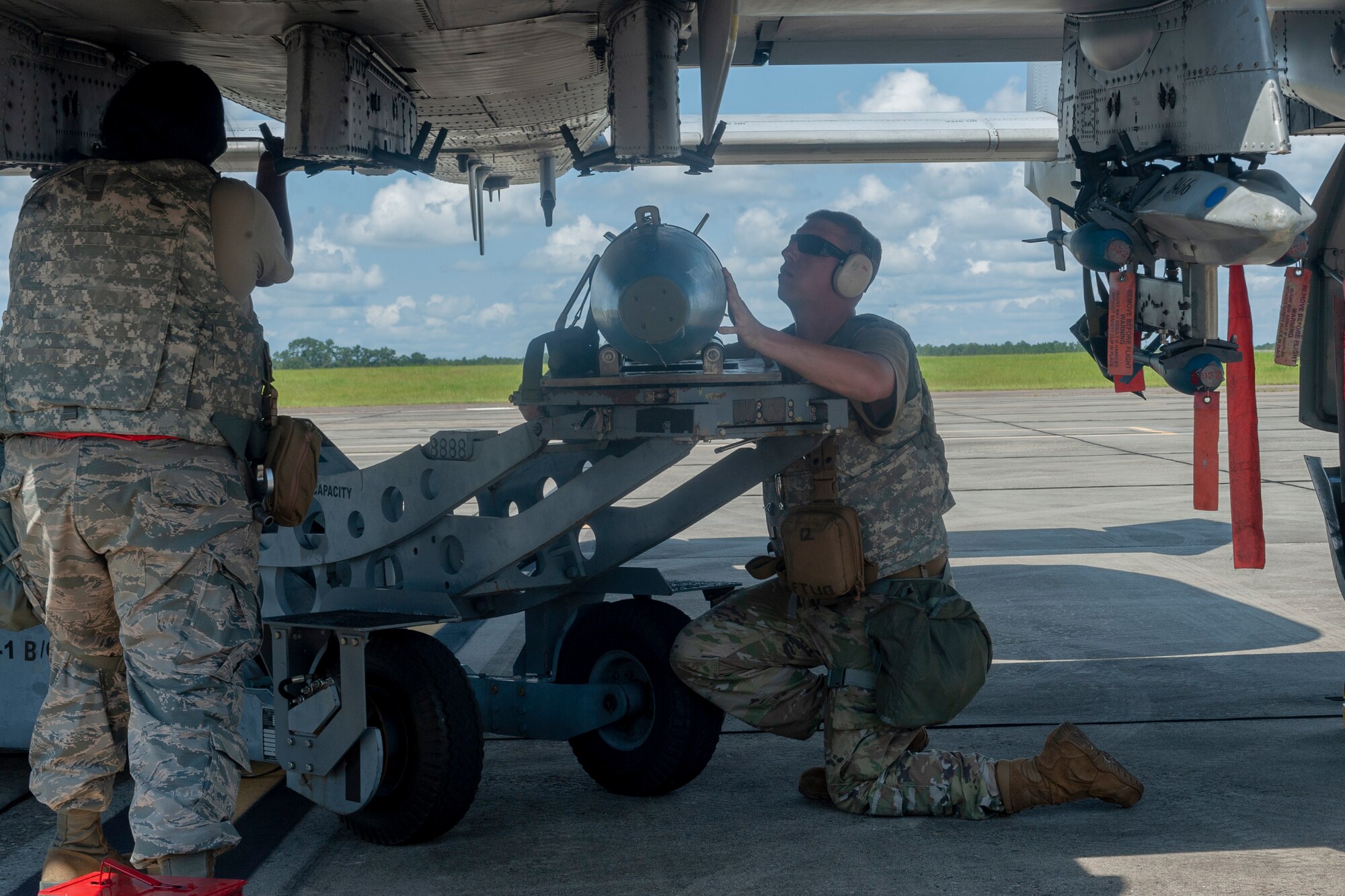 Photo of Airmen loading a munition