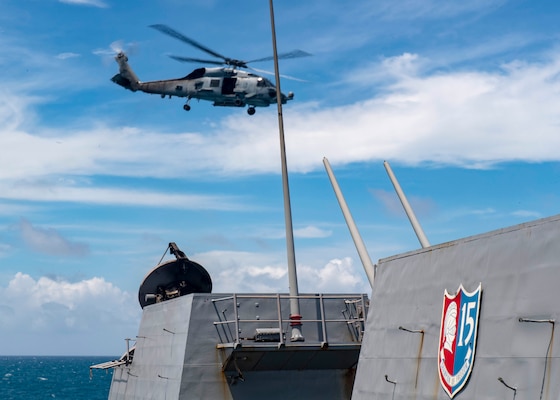 An MH-60R Sea Hawk helicopter assigned to Helicopter Maritime Strike Squadron (HSM) 51 takes off from the flight deck as the Arleigh Burke-class guided-missile destroyer USS Mustin (DDG 89) conducts routine operations.