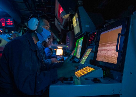 Gunner’s Mate Seaman Daniel Campos, from Chico, Texas, stands optical sighting system watch in the combat information center as the Arleigh Burke-class guided-missile destroyer USS Mustin (DDG 89) conducts routine operations.