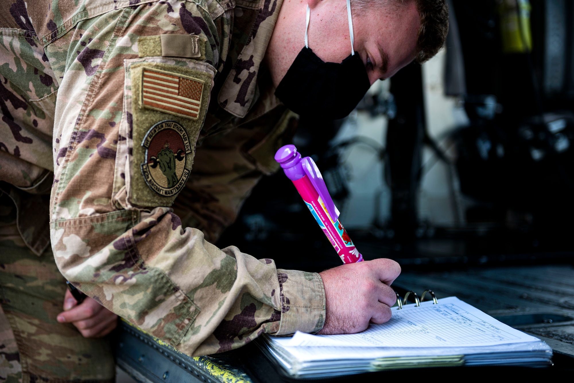 Photo of Airman initials a status sheet.