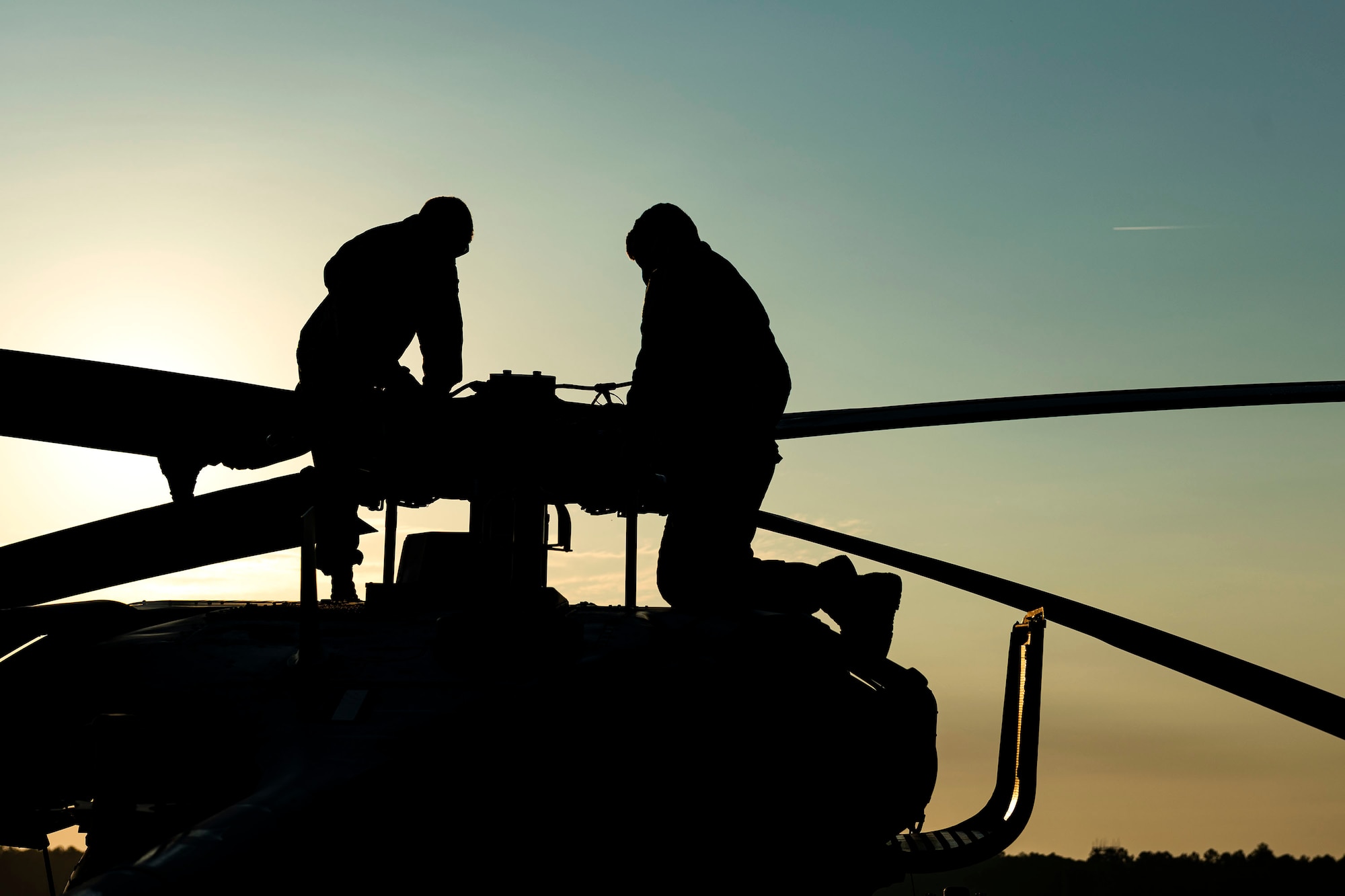Photo of Airmen looking over an HH-60G Pave Hawk.