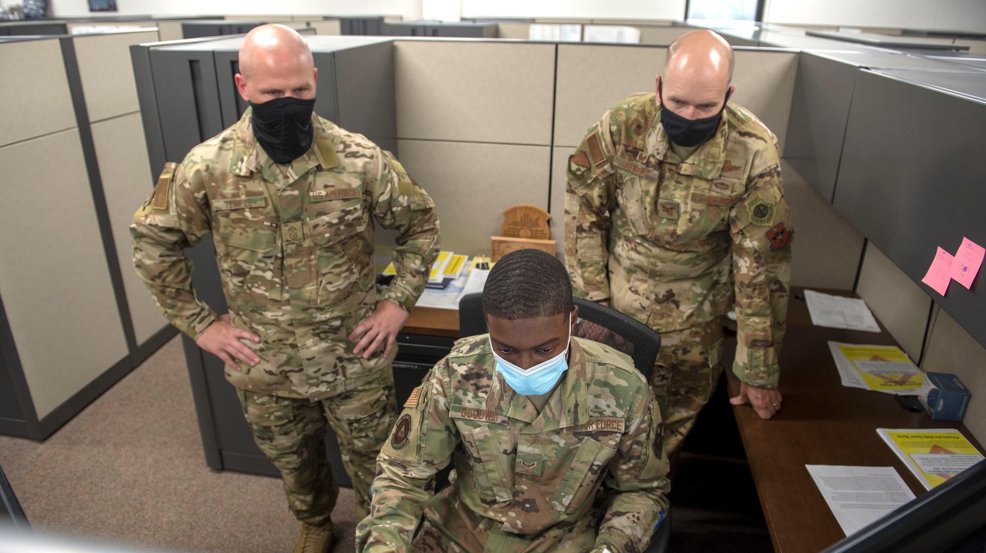 Airman 1st Class Eric Goodwin, 49th Comptroller Squadron financial operations technician, briefs, from left to right, Chief Master Sgt. Thomas Temple, 49th Wing command chief, and Col Ryan Keeney, 49th Wing commander, Aug. 17, 2020, on Holloman Air Force Base, New Mexico. Goodwin has taken on the responsibility of four Airmen by running the Permanent Change of Station section for the last six months. (U.S. Air Force photo by Staff Sgt. Christine Groening)