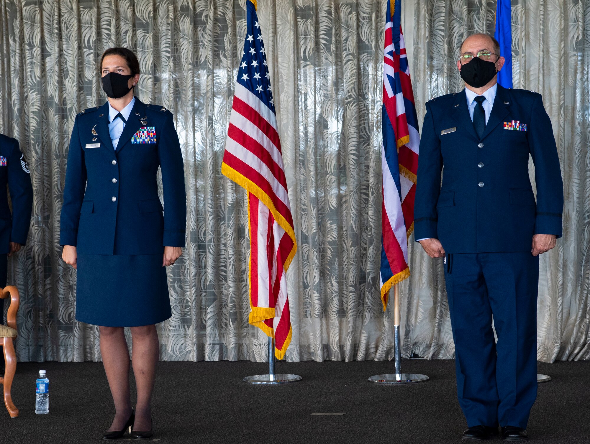 A photo of U.S. Air Force Col. Athanasia Shinas, 624th Regional Support commander, and Col. Lee Bradshaw, the former commander of the 624th Aeromedical Staging Squadron, standing at attention during the reading of Bradshaw’s retirement order during his retirement ceremony at Joint Base Pearl Harbor-Hickam, Hawaii, Aug. 9, 2020.